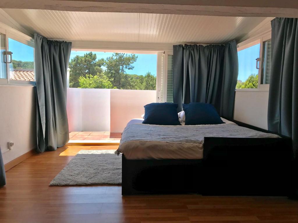 1 dormitorio con cama y ventana grande en Falésia Beach Villa, en Olhos de Água