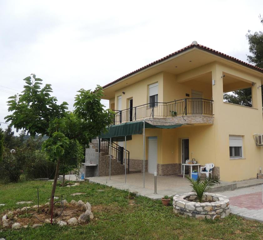 a large yellow house with a balcony at Villa Platskos vol3 in Kriopigi