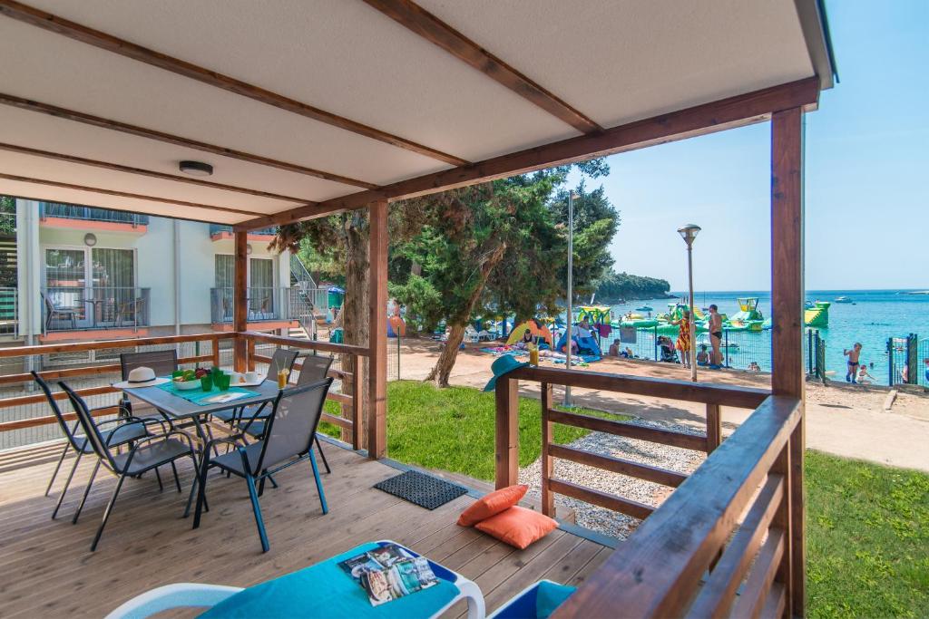 Centinera Deluxe Mobile Homes في بنجول: سطح مع طاولة وكراسي وإطلالة على الشاطئ