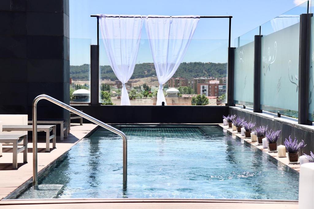 a swimming pool on the roof of a building at PCM Forum Alcalá in Alcalá de Henares