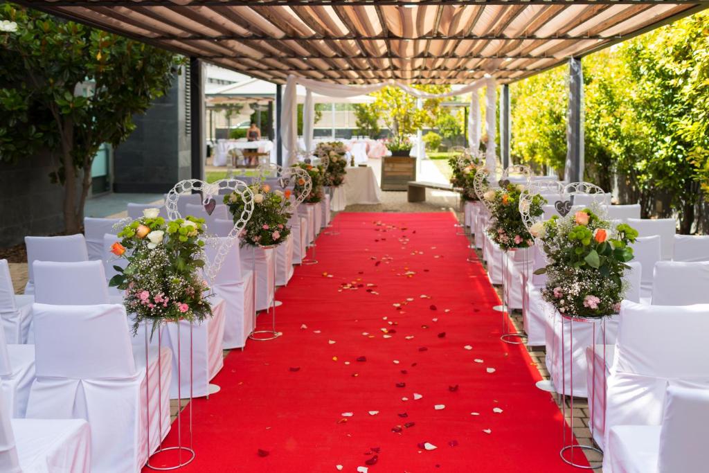 a row of tables and chairs with a red carpet at PCM Forum Alcalá in Alcalá de Henares