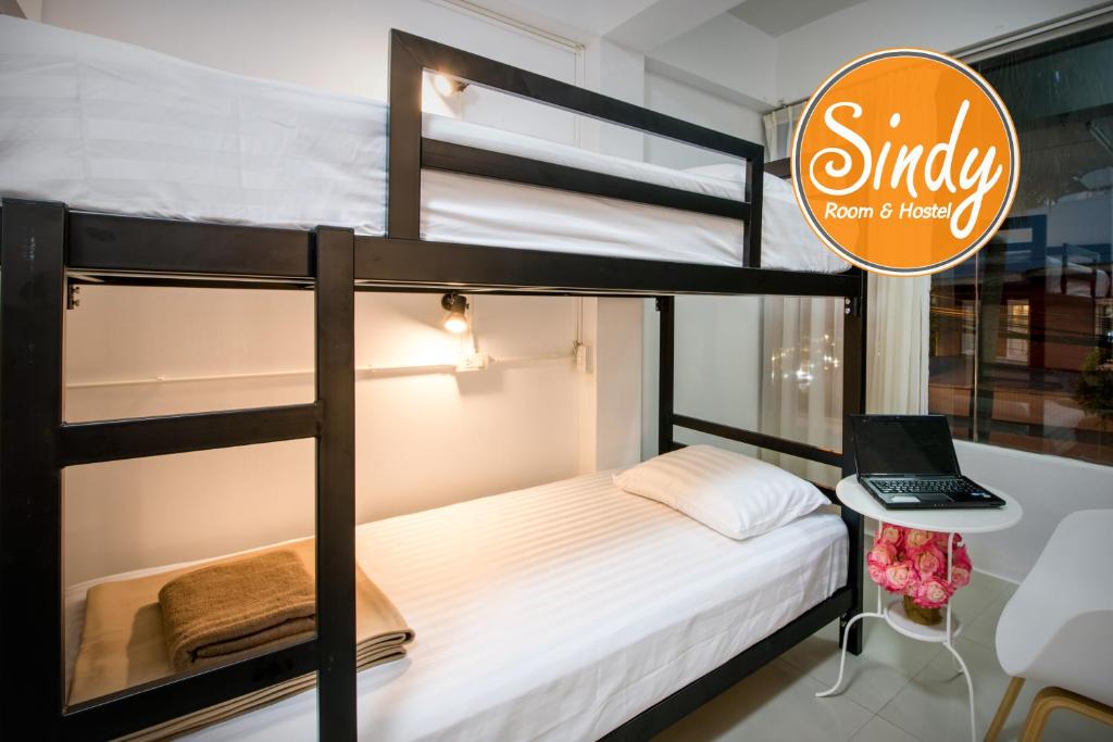 een slaapkamer met een stapelbed en een laptop op een bureau bij Sindy's Hostel in Pattaya