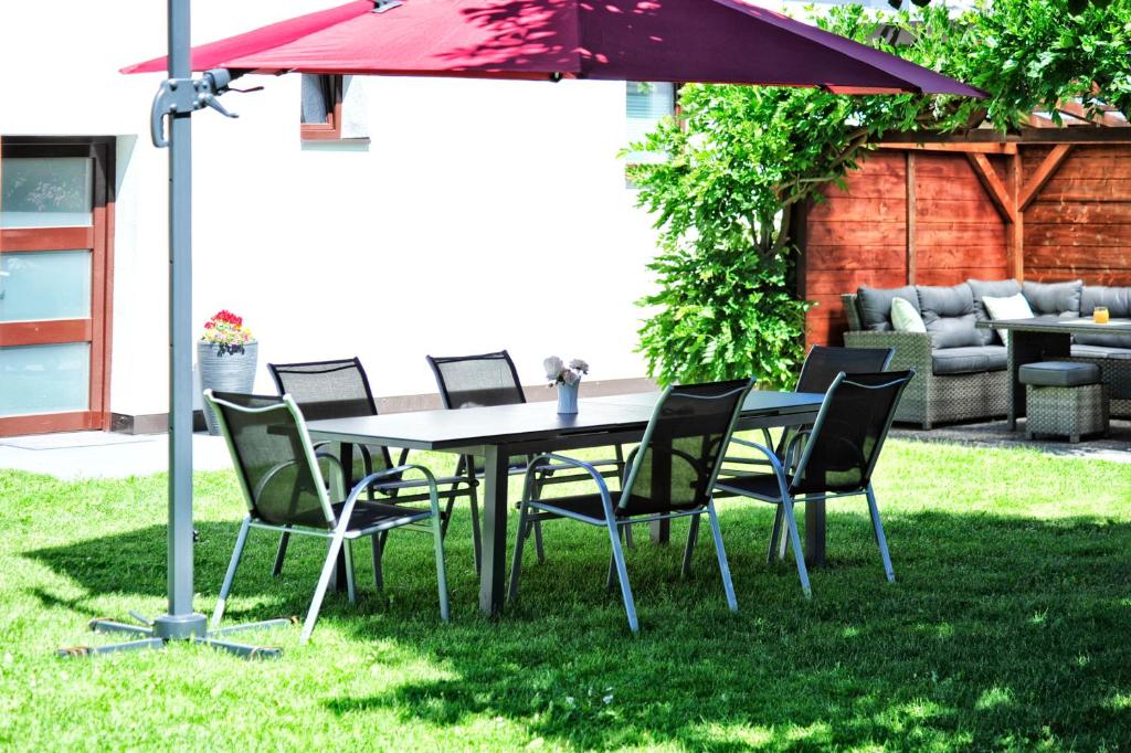 a table and chairs under an umbrella in a yard at Aparthaus Teresa in Ried im Oberinntal