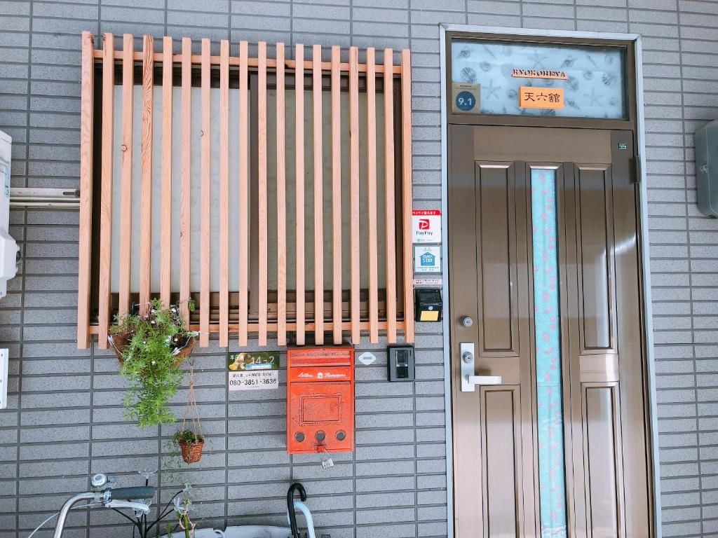 a building with a door and a sign on it at Ryokoheya Tenrokukan in Osaka