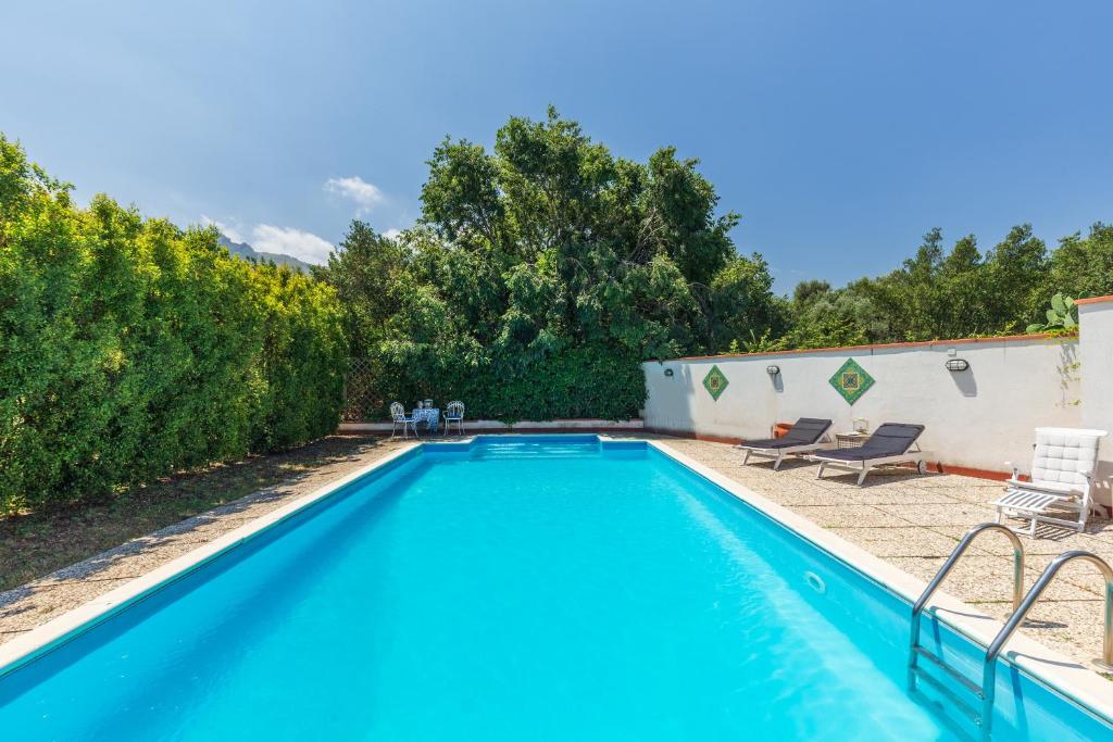a swimming pool in a yard with chairs and trees at Domus Sicily - Villa Conca d'Oro with Pool in Palermo