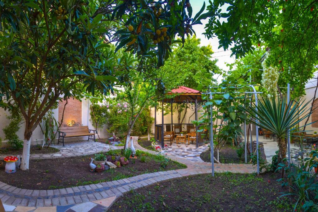 a garden with a table and a bench and trees at Hotel Livin in Tbilisi City
