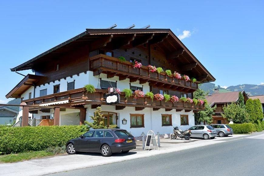 a building with a balcony with flowers on it at Pension Hohe Salve in Westendorf