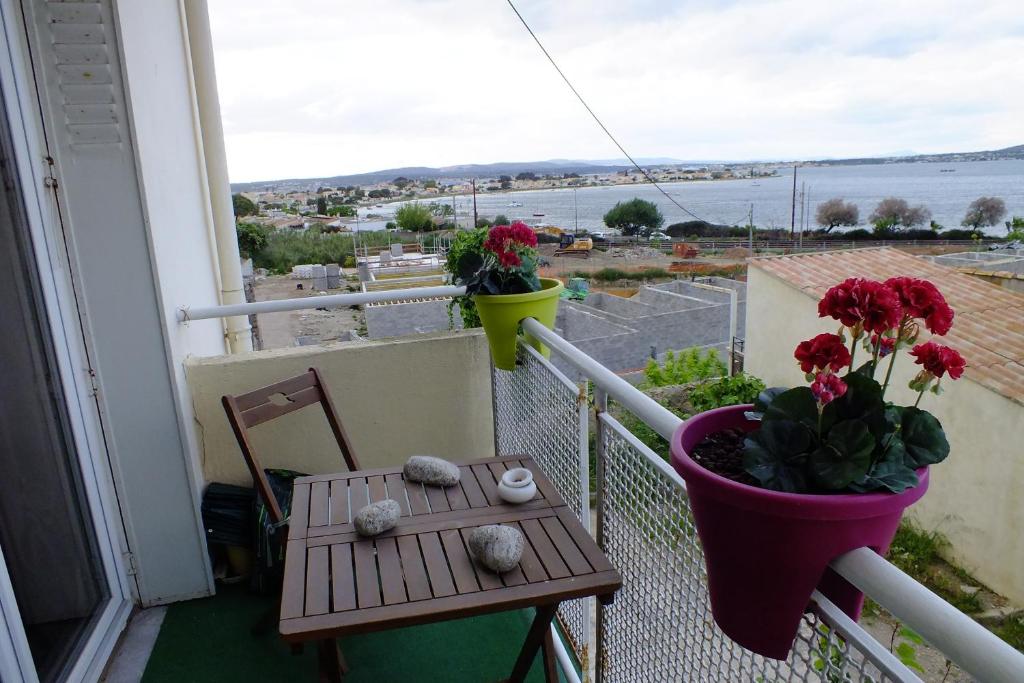 - un balcon avec une table et un vase de fleurs dans l'établissement F3 avec parking le dauphin, à Sète
