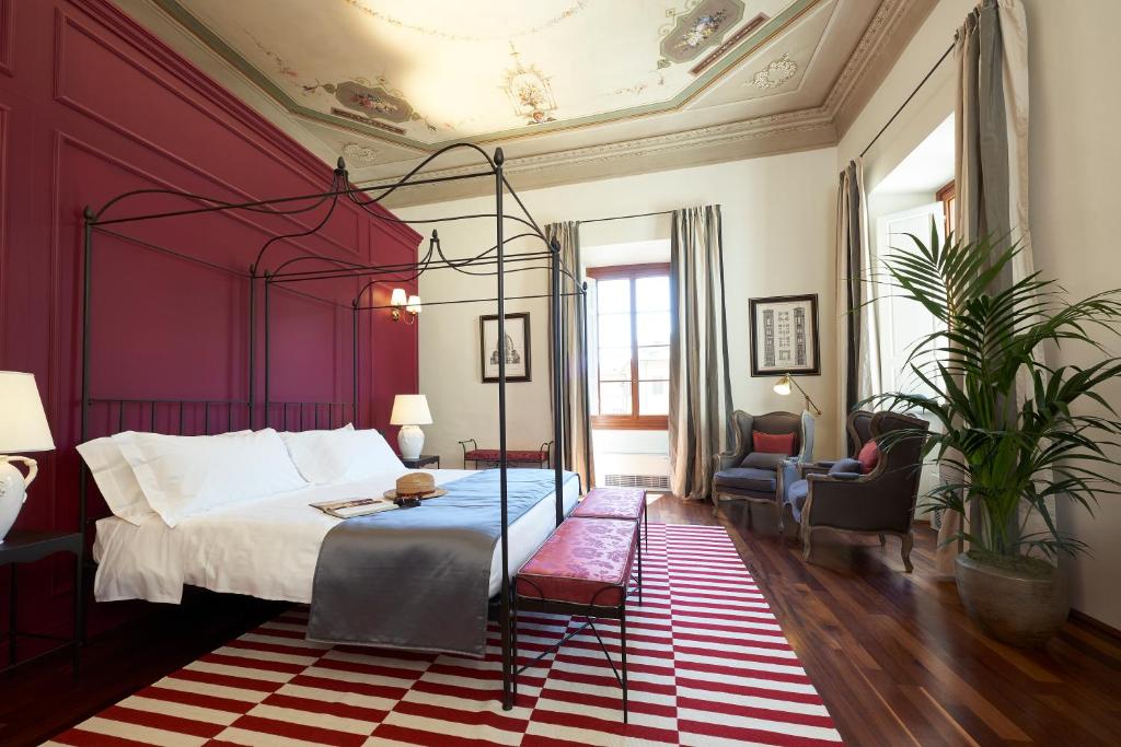 a bedroom with a bed with a red wall at Peruzzi Urban Residences in Florence