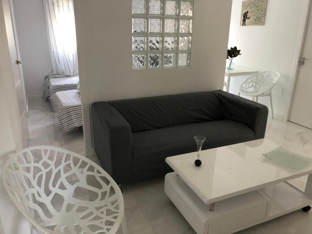 un soggiorno con un divano nero e un tavolo di Bubu Beach 2-A a Los Cristianos