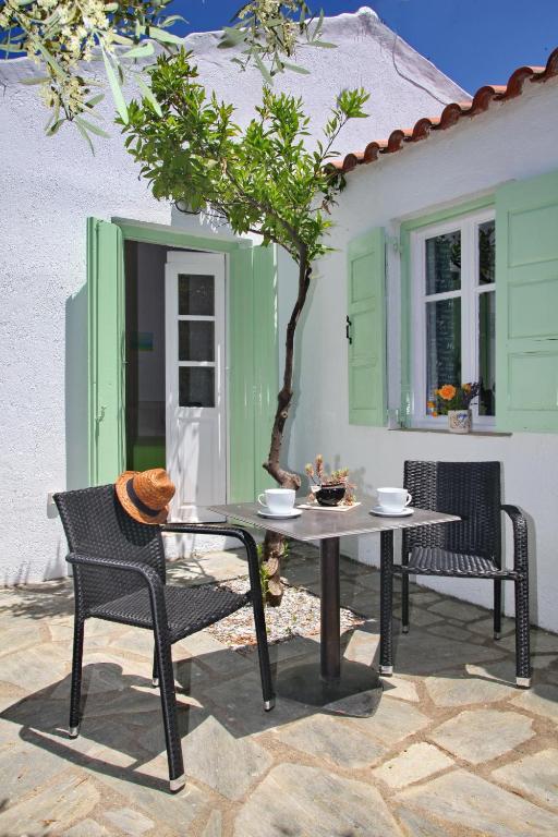 a table and chairs on a patio in front of a house at Liogerma Cottage in Panormos Skopelos