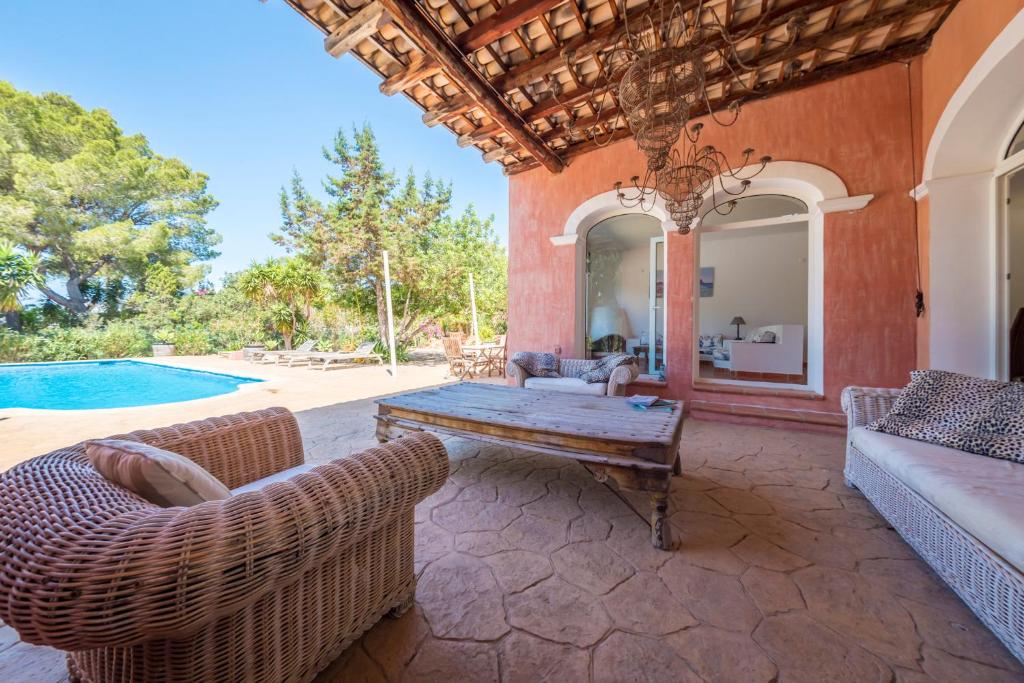 サン・ジョセップ・デ・サ・タライアにあるExclusive Villa in Porroigのパティオ(テーブル、椅子付)、プールが備わります。