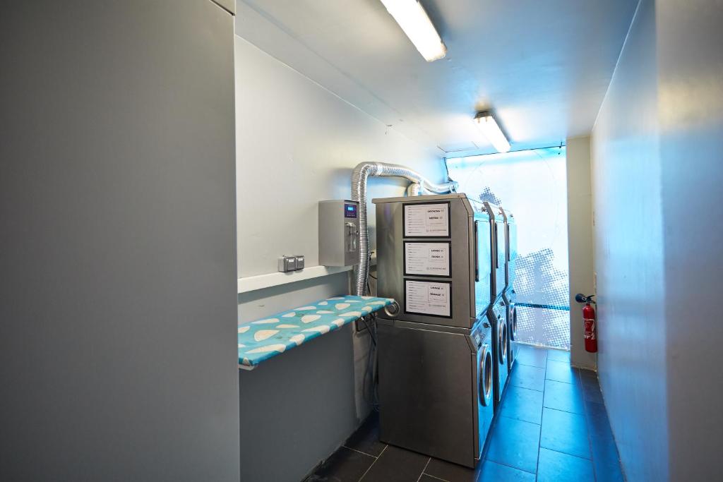 a small room with a kitchen with a refrigerator at St Christopher's Inn Paris - Canal in Paris