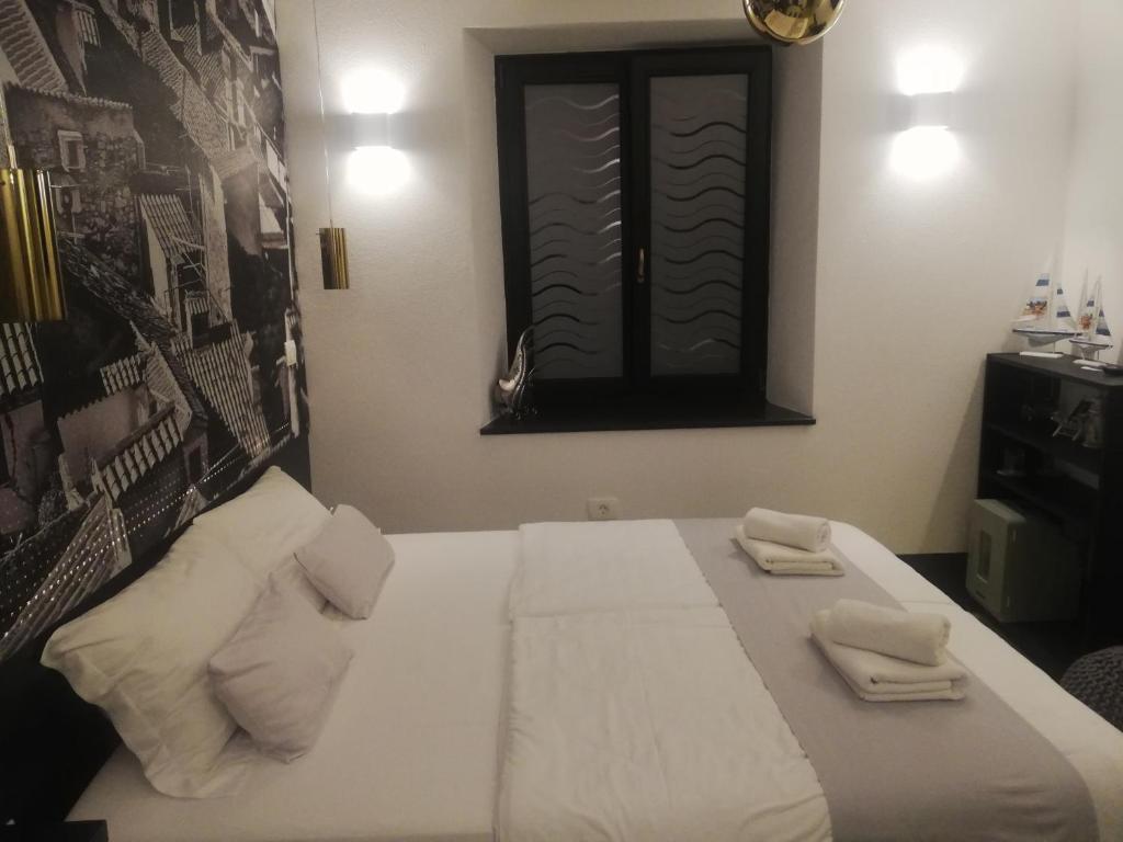 a bedroom with a bed with two towels on it at Camera al Porto Antico in Piran