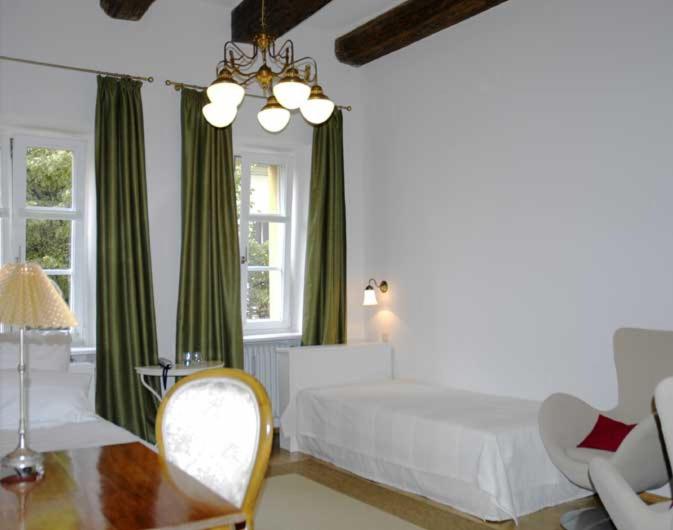 1 dormitorio con 1 cama, mesa y sillas en Hotel Goldenes Kreuz, en Regensburg