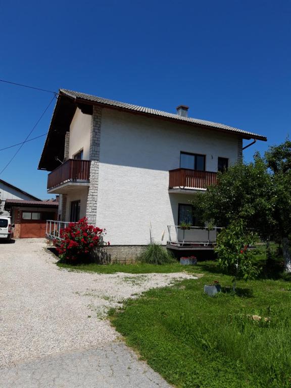 a white house with balconies on the side of it at Studio apartman CENTAR in Ogulin