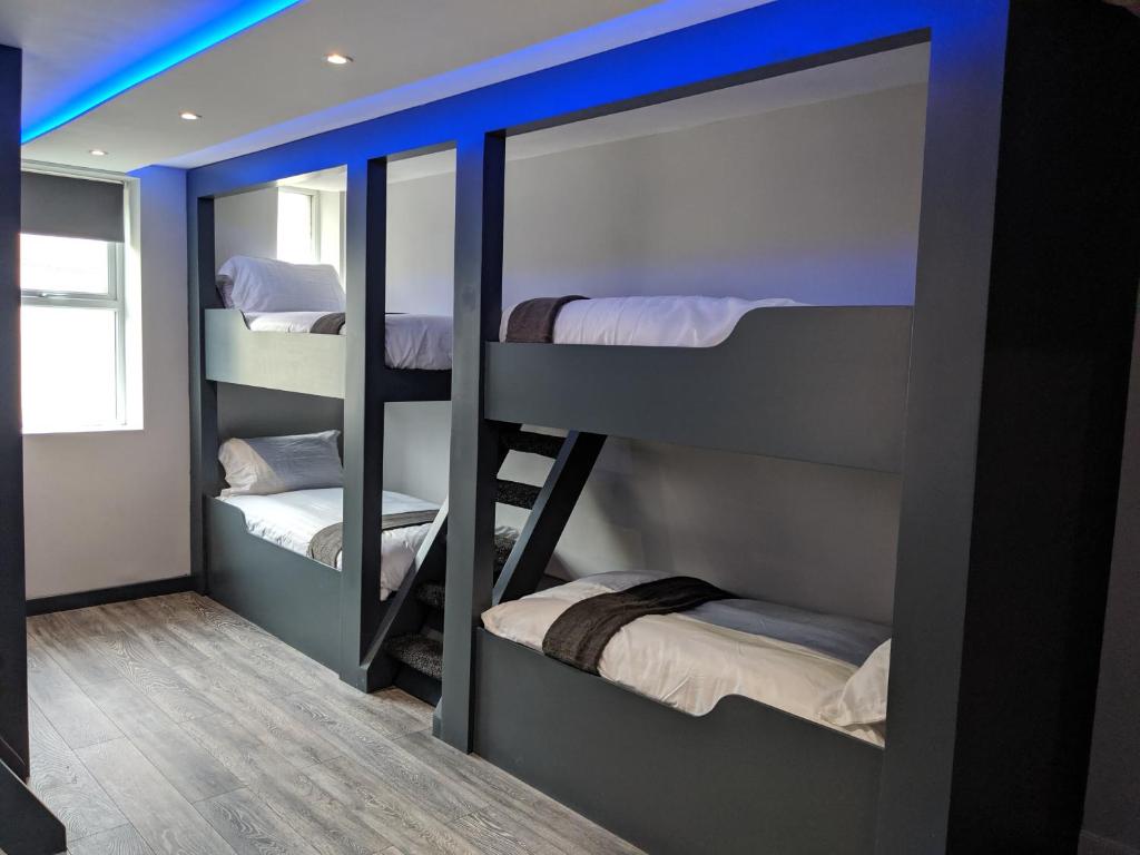 a bunk room with three bunk beds in it at Vibe Holiday Apartments in Blackpool