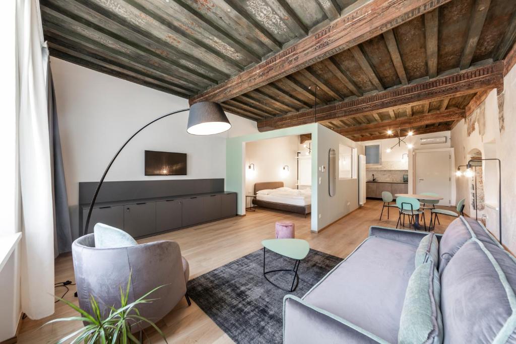 een woonkamer met een bank en een tafel bij Stay COOPER l Cooper apartments in Bolzano
