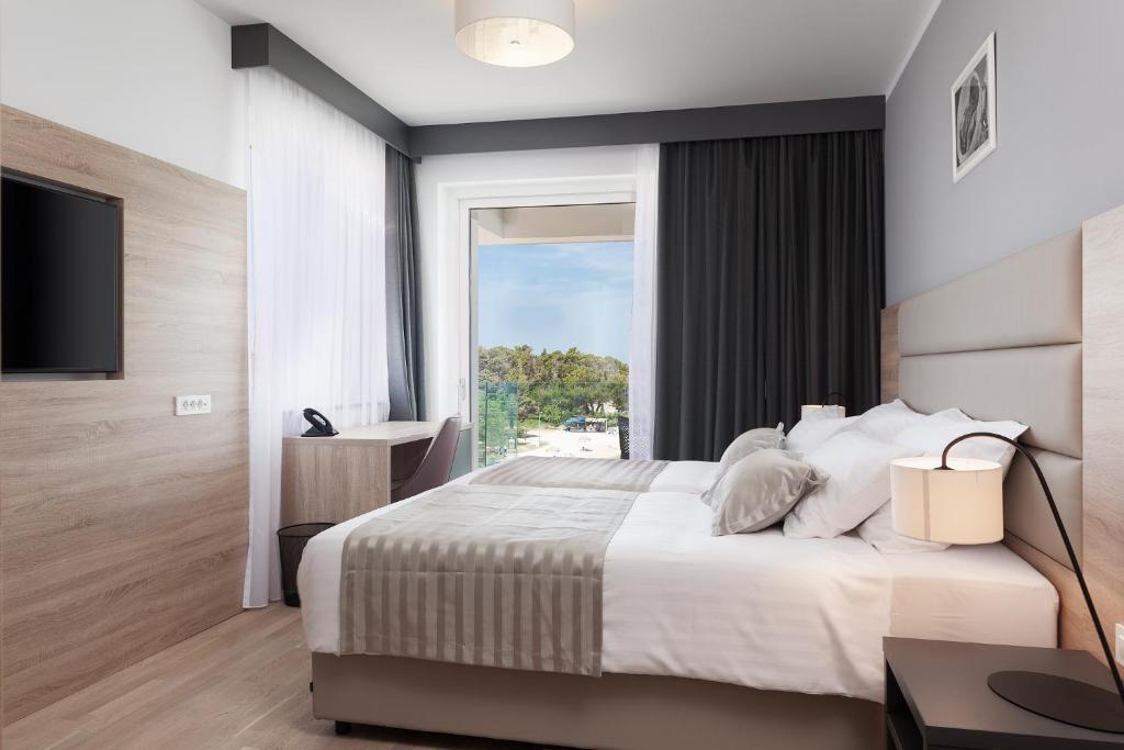 Postel nebo postele na pokoji v ubytování Kaneo beach hotel Novalja