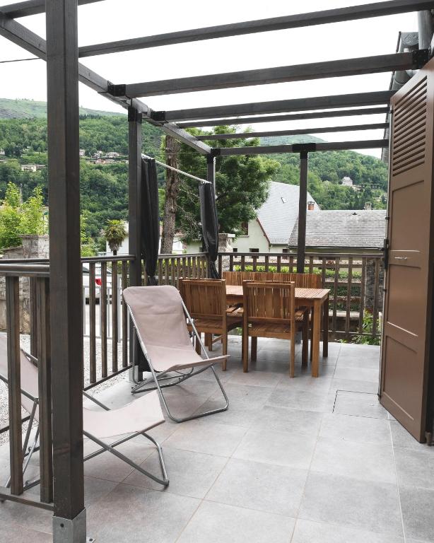 a patio with a table and chairs on a deck at Au chalet des quatre saisons in Ax-les-Thermes