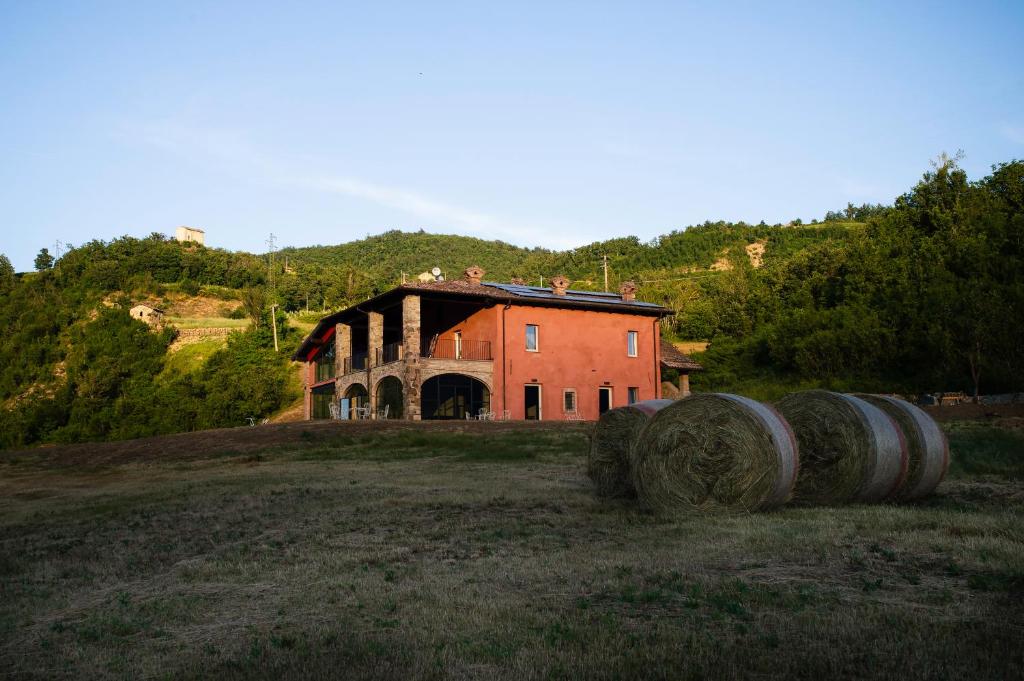 an old house with hay bales in front of it at Relais SANT'AMBROGIO in Bobbio