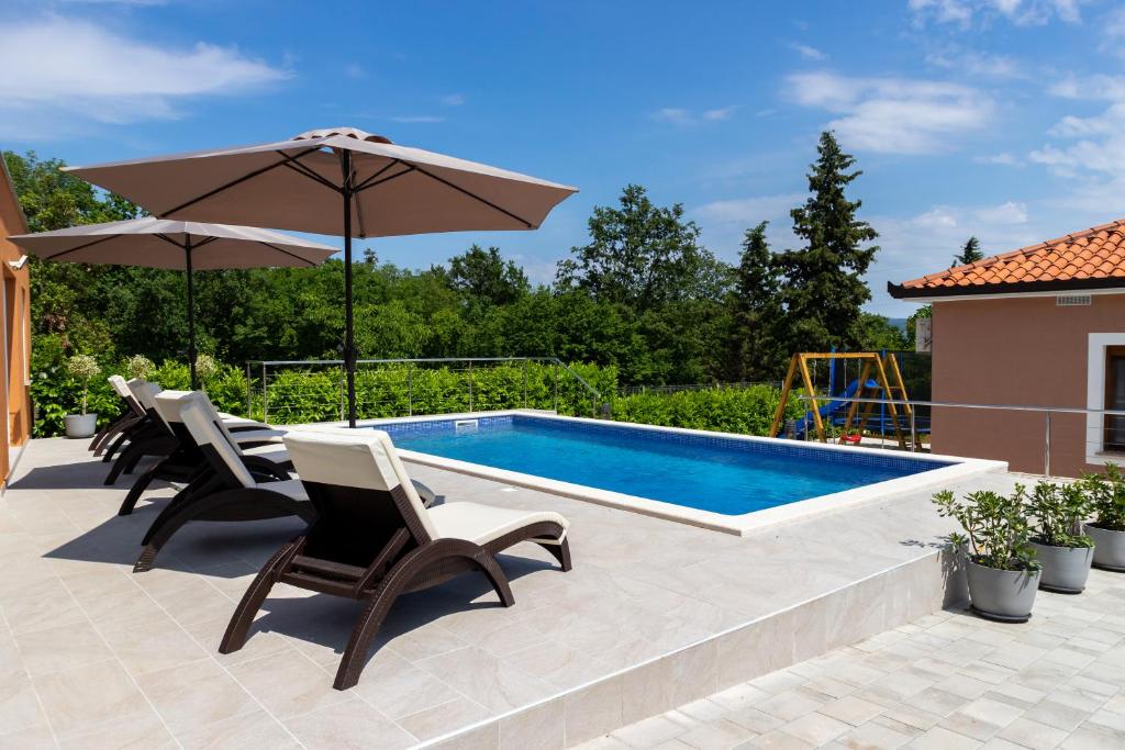 una piscina con sedie e un ombrellone di Villa Astra a Barban