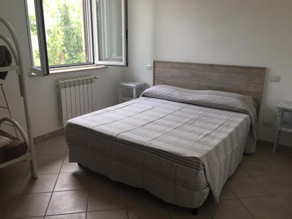 1 dormitorio con 1 cama en una habitación con 2 ventanas en Da Nonna Laura al Circeo, en San Felice Circeo