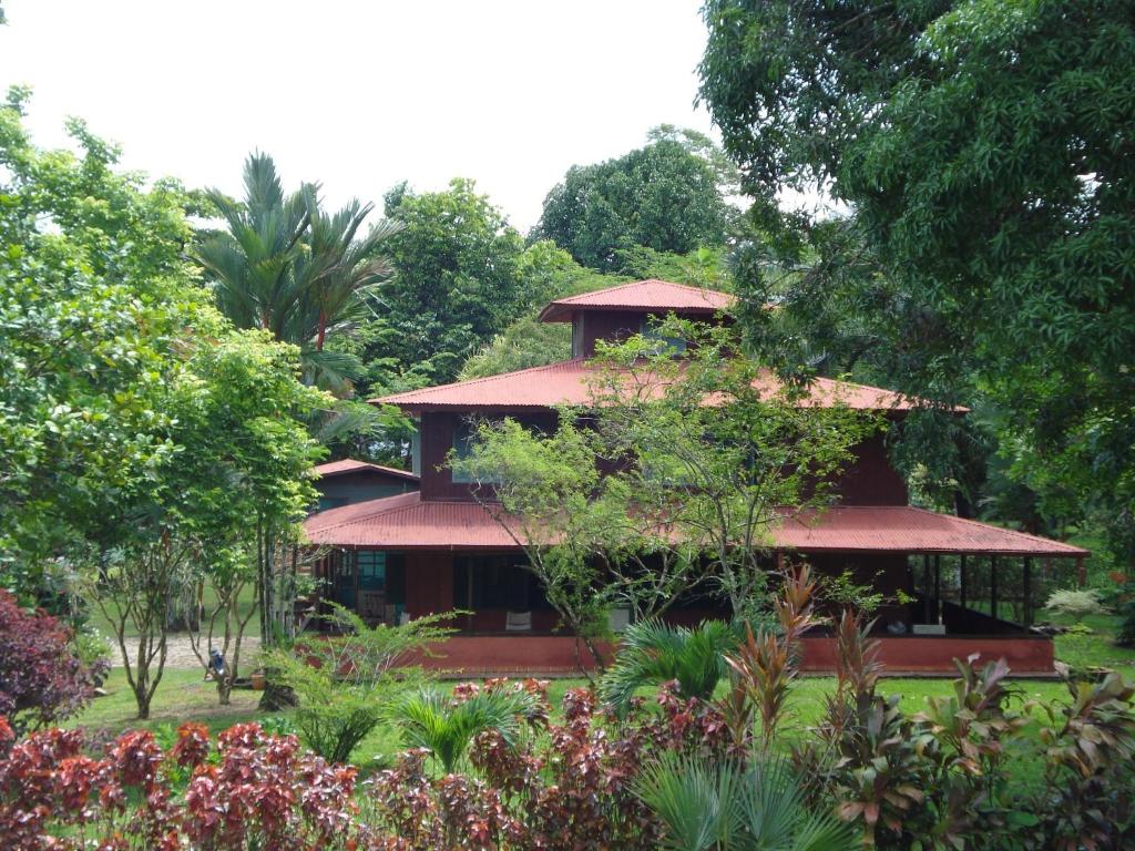 a building in the middle of a garden with trees at Hotel Veragua River House in Sierpe