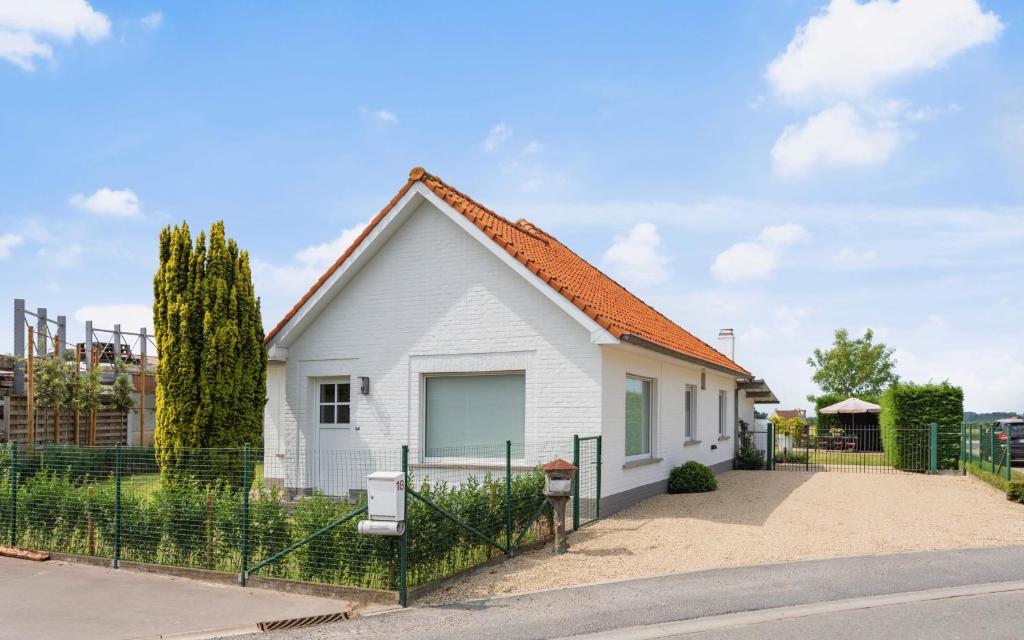 een wit huis met een oranje dak bij Vlaeberg Cottage in Kortemark