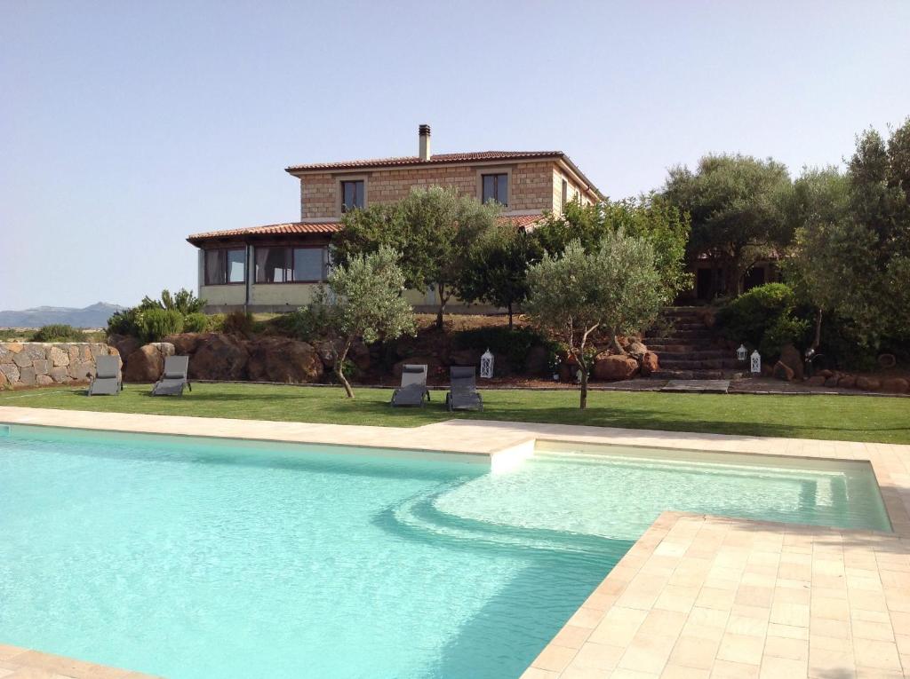 uma casa com piscina em frente a uma casa em Agriturismo Sa Murta em Sennariolo