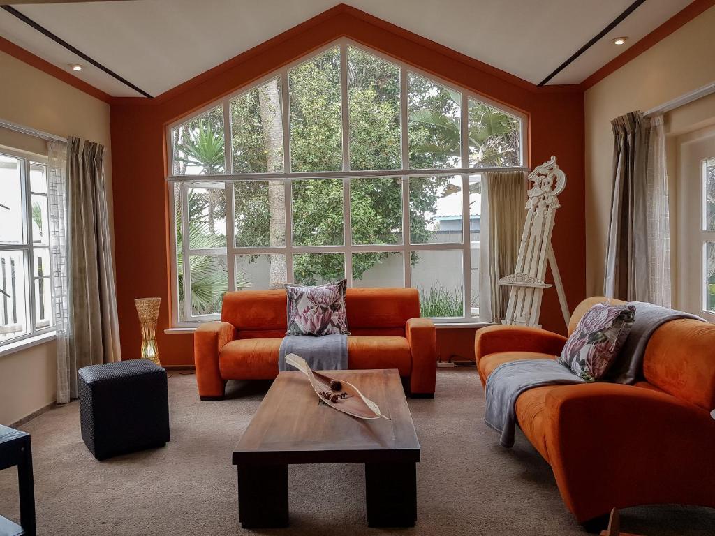 uma sala de estar com mobiliário laranja e uma grande janela em 9 on Kiebitz em Swakopmund