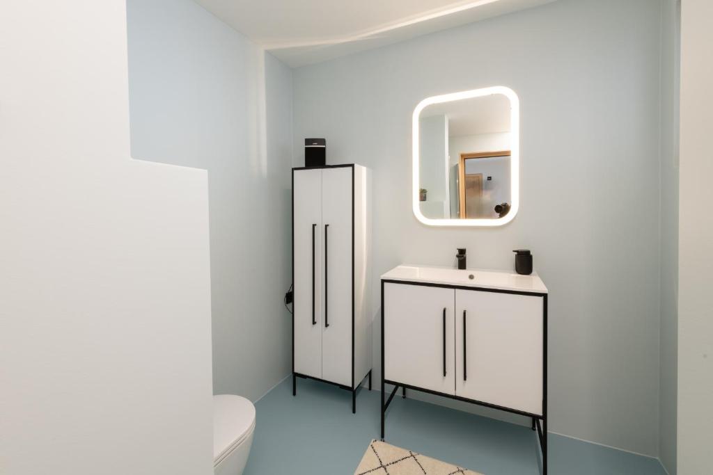 a bathroom with a toilet and a sink and a mirror at Zu Gast bei den Hagspiels in Hittisau