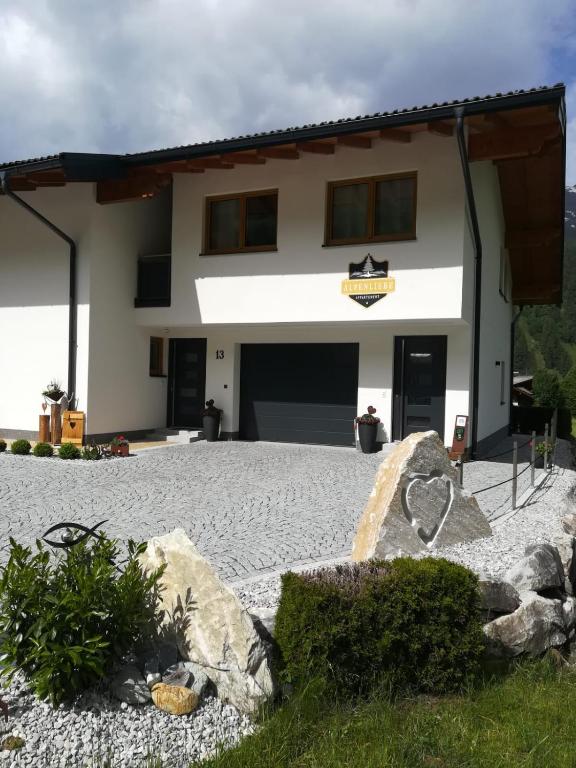 a house with a stone driveway in front of it at Appartement Alpenliebe in Rauris