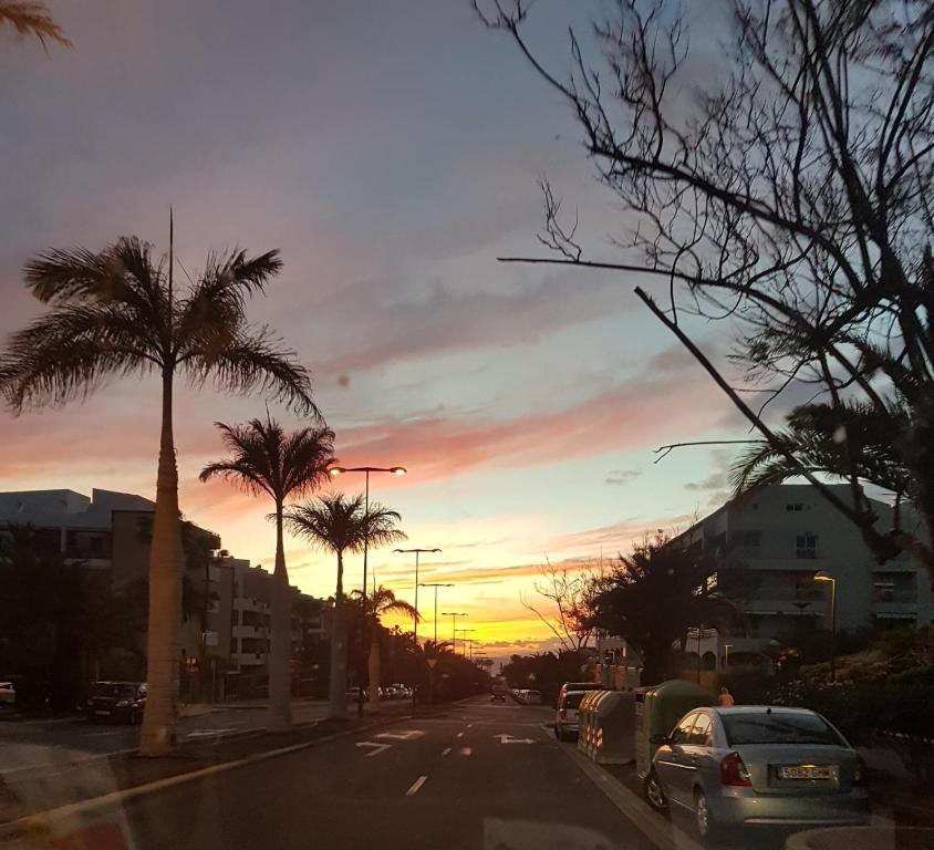 eine Stadtstraße mit Palmen und Sonnenuntergang in der Unterkunft SAFA 2 in Palm-mar