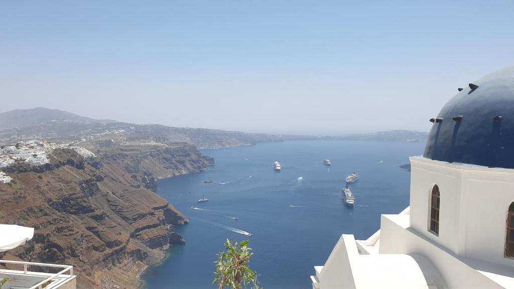 a view of a body of water with boats in it at Imer Villas in Imerovigli