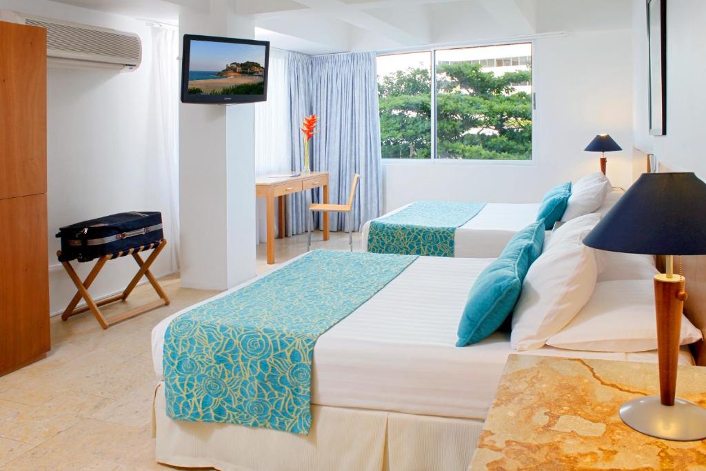 Un pat sau paturi într-o cameră la Hotel Oceania Cartagena