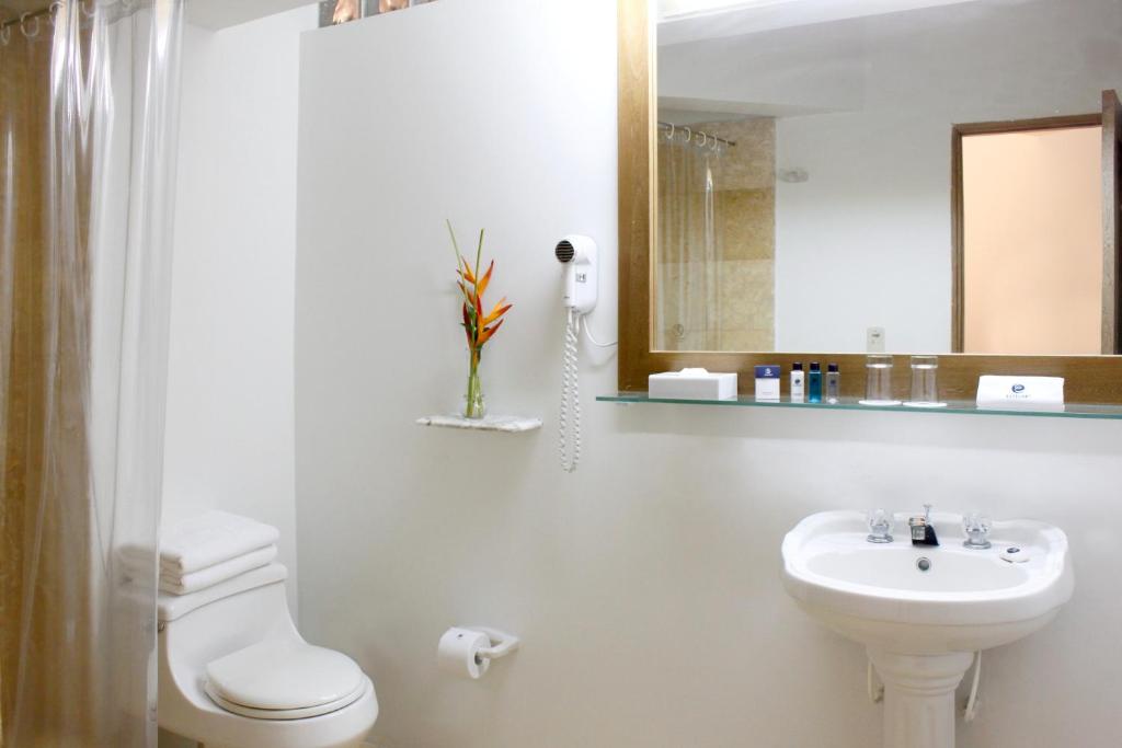 a bathroom with a sink and a toilet and a mirror at Hotel Oceania Cartagena in Cartagena de Indias