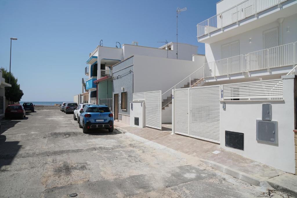 Un coche aparcado en un aparcamiento junto a un edificio. en Casa Vacanze Pirandello, en Torre Lapillo