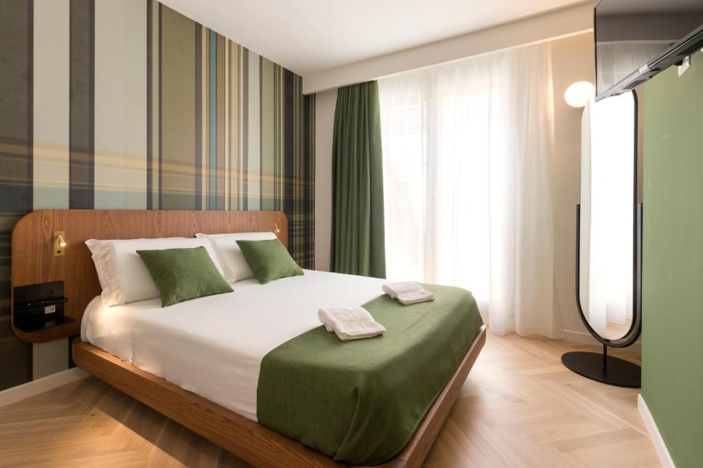 a bedroom with a large bed with green pillows at Metropolitan Suites in Ancona