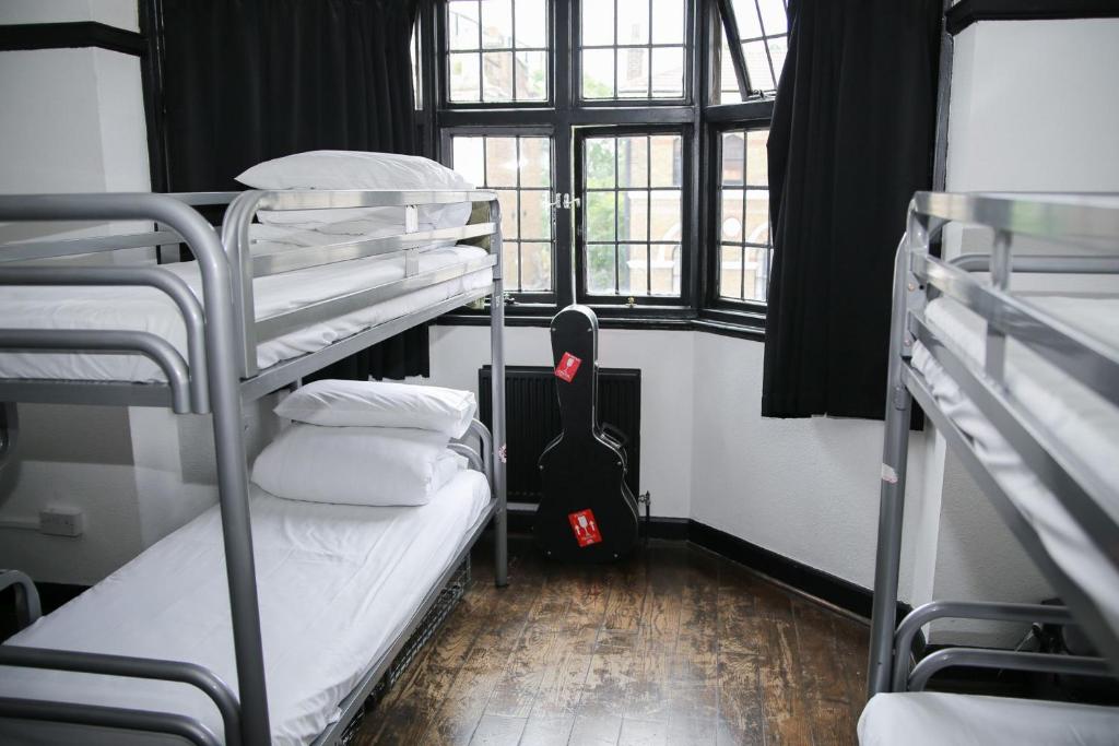 a room with two bunk beds and a window at St Christopher's Inn Camden in London