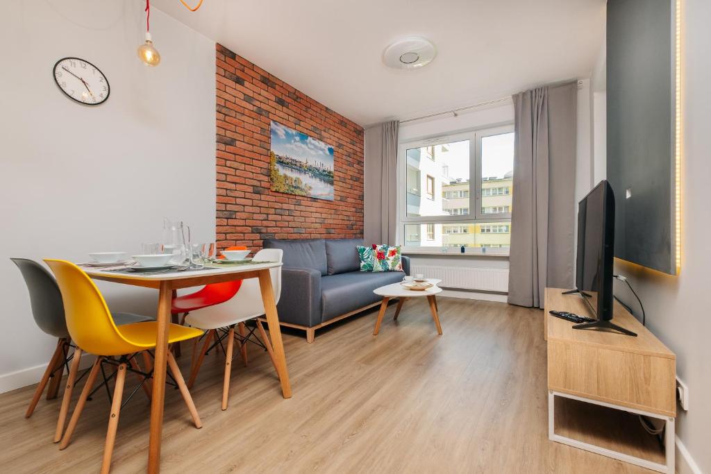 - un salon avec une table à manger et une télévision dans l'établissement Stare Bielany 2-Bedroom Apartment, à Varsovie