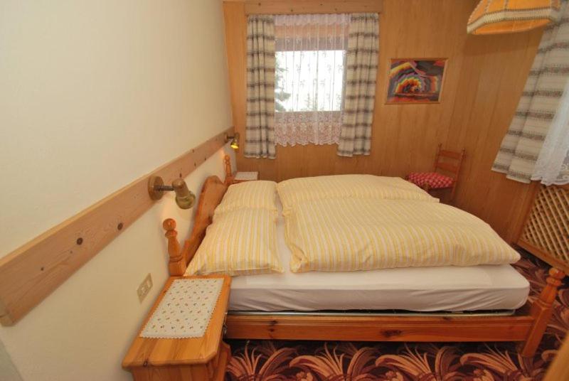 a small bedroom with a bed and a window at Appartamento N. 7 in Livinallongo del Col di Lana