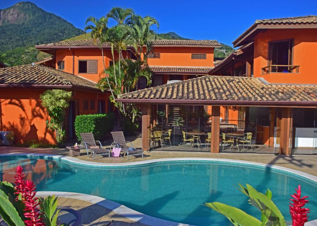 a swimming pool in front of a house at Pousada Mais Bella in Ilhabela