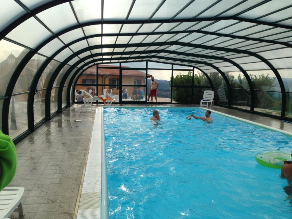twee mensen zwemmen in een zwembad met een arthouse bij Appartment- Garofano in Apecchio