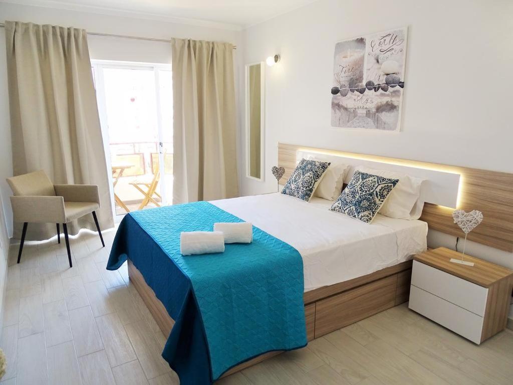 a bedroom with a large bed with a blue blanket at Luz Apartments in Portimão