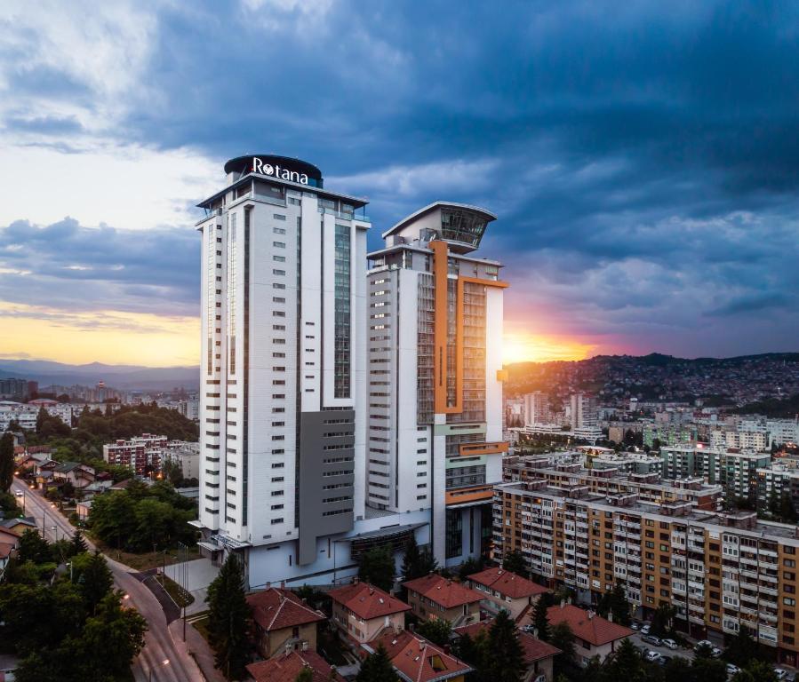 a large white building with a sign on top of it at Bosmal Arjaan by Rotana in Sarajevo