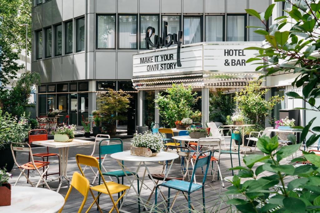 デュッセルドルフにあるRuby Leni Hotel Dusseldorfの建物の前にテーブルと椅子付きのパティオ