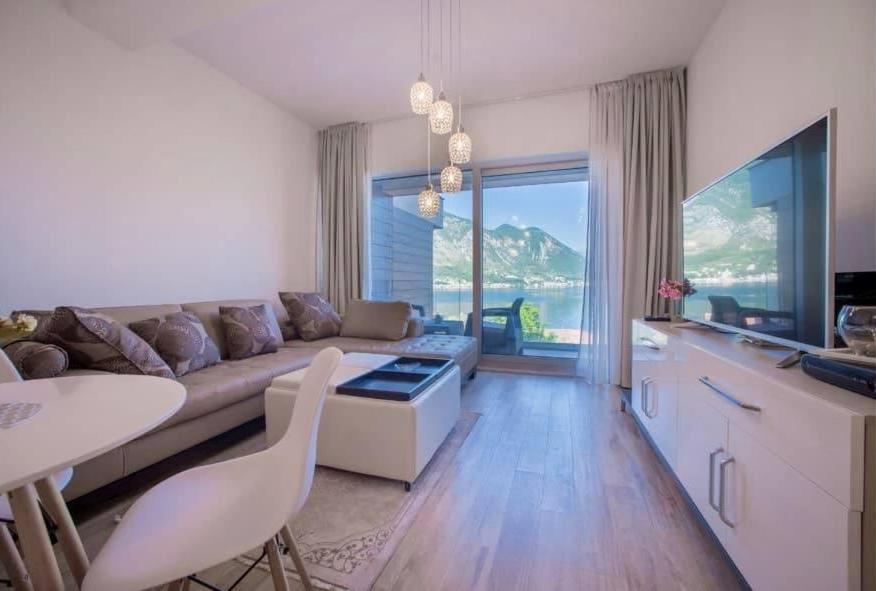 ein Wohnzimmer mit einem Sofa und einem Tisch in der Unterkunft LaNi Lux View Apartment with Pool in Kotor