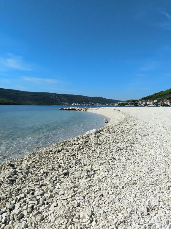 a beach with a rocky shoreline and the water at Obala 111 in Poljica