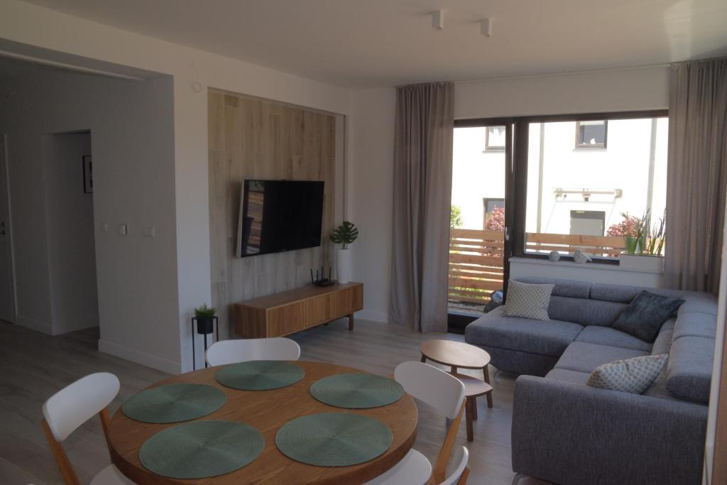 uma sala de estar com um sofá e uma mesa em Kite Apart em Mechelinki